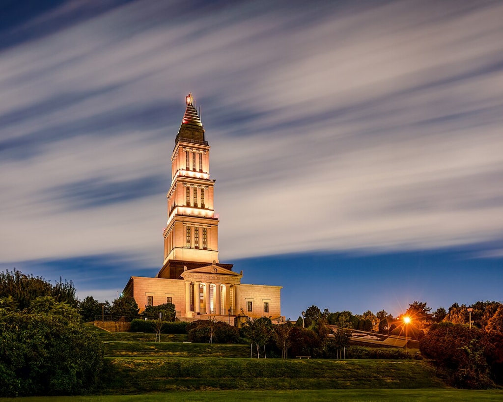 This night-time photograph showcases the George Washington Masonic National Memorial in Alexandria, Virginia. The memorial, a National Historic Landmark, stands as a modern tribute to the architecture of the ancient Lighthouse of Alexandria, one of the Seven Wonders of the Ancient World.