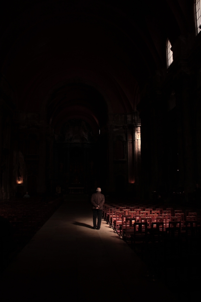 Photographer captures man walking in church in chiaroscuro composition